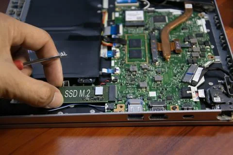 The technician is installing an M.2 hard drive. Stock Photos