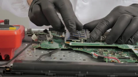 Technician installing memory module on laptop motherboard during hardware repair Stock Footage 334387750