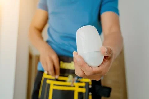 A technician installing motion sensor detector in a modern apartment. Foto stock