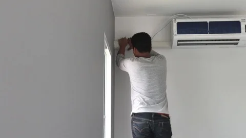 Technician installing a plastic cover on the air conditioner pipe. Stock-Footage 98451197
