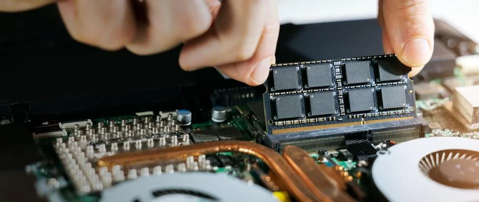 Technician installing ram memory module in laptop motherboard. computer hardw Stock-Fotos