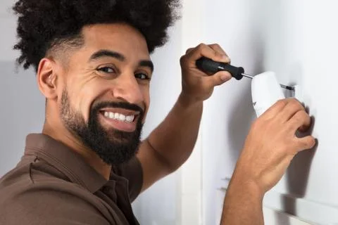 Technician Installing Security System Motion Sensor Stock Photos