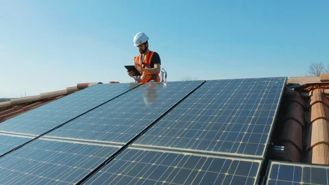Technician installing solar panel on domestic home rooftop Stock Footage