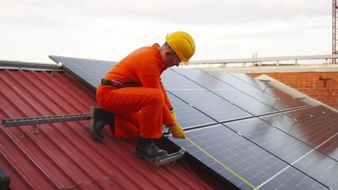 Technician installing solar panels on a building rooftop Stock Footage 343894602