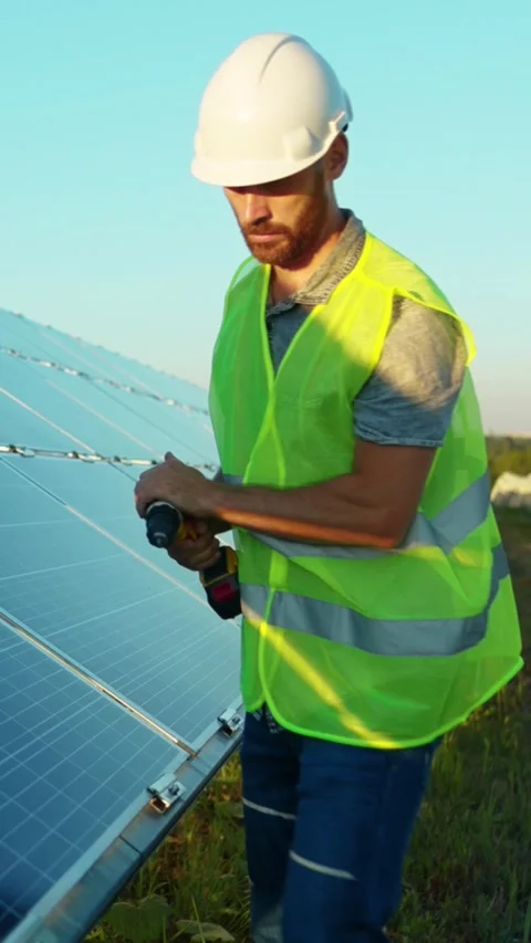 A technician is installing solar panels as part of a renewable energy project Stock Footage 314206365