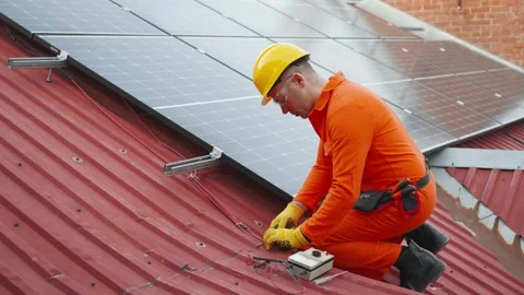 Technician installing solar panels on a roof Stock Footage 343895072
