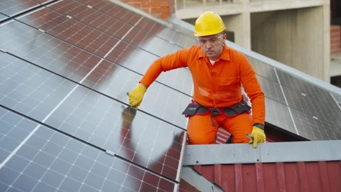 Technician installing solar panels on rooftop Stock Footage 343894666