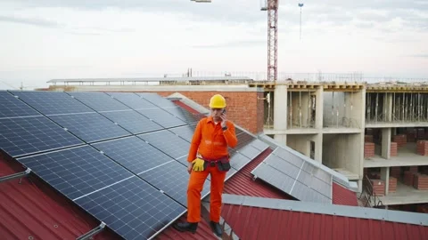 Technician installing solar panels talking on the phone Stock Footage 343894972