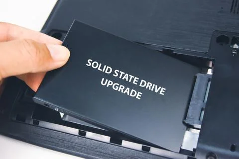 A technician installs a Solid State Drive (SSD) Stock-Fotos