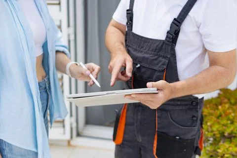 Technician interacting with customer, providing service and receiving digit.. Foto stock