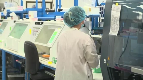 A technician at a laboratory bench in a crime laboratory testing DNA samples Stock Footage 345299156