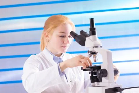 Technician in the laboratory using a microscope Foto stock