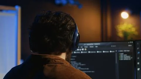 Technician listening music while using coding to fortify firewalls Stock-Fotos