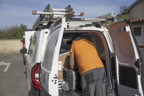 Technician loading electrical replacement components into a company van rea.. Fotos Stock
