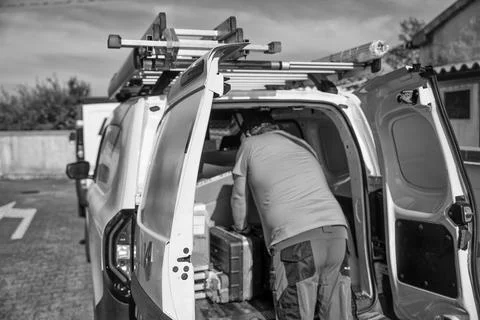 Technician loading electrical replacement components into a company van rea.. Fotos Stock