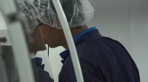 Technician Looking Inside Machine in Cleanroom, Reflection off glass Stock Footage 10895364