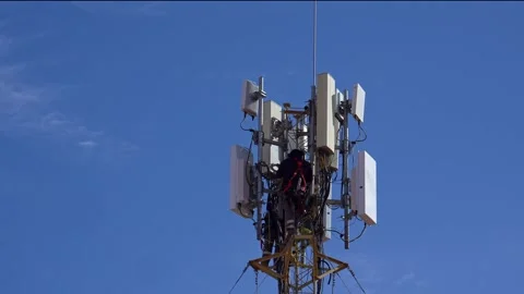 Technician maintaining a 5g cellular network tower for mobile phones Stock Footage 332786139