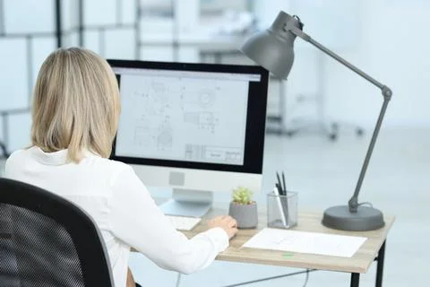 Technician making digital engineering drawing on computer at desk in office.. Foto stock