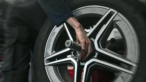 Technician man balancing wheel closeup tire workshop. Mechanic work car service. 動画素材 272761095