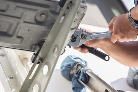 Technician man hands using a wrench fixing modern air conditioning system Foto stock