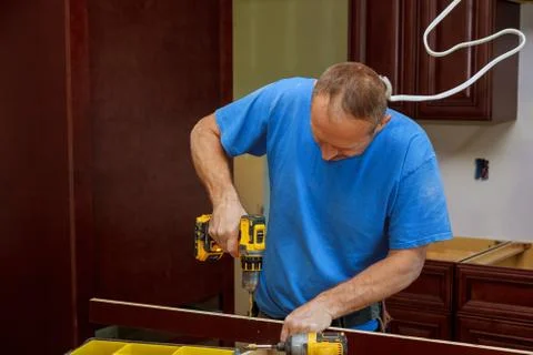 Technician man installing kitchen cabinets Stock-Fotos