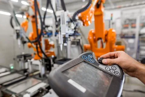 Technician man programming robot in automotive industrial, professional Stock Photos