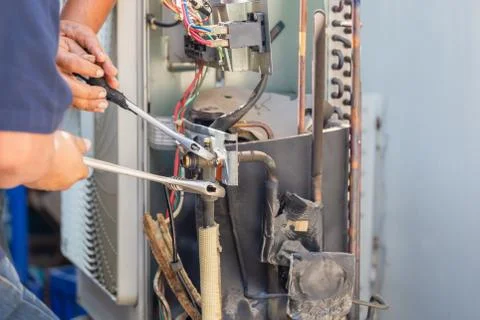 Technician man using a wrench fixing modern air conditioning system Fotos Stock