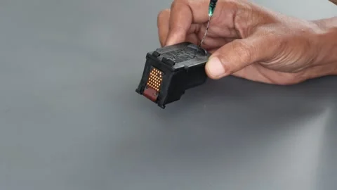 ​A technician manually refilling a black printer ink cartridge Stock Footage 332124535