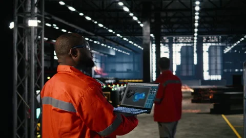 Technician in a manufacturing facility uses automation software on laptop Stock Footage 322205905
