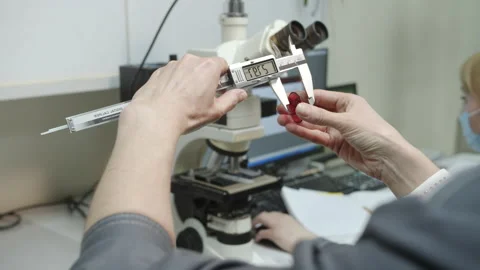 Technician measures thickness of washer using caliper Stock Footage 228780672