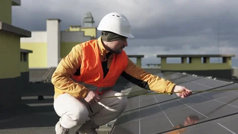 Technician measuring solar panels on rooftop. Stock Footage 320290257