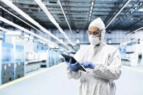 Technician in microchip factory testing silicon wafer batches with tablet Stock Photos