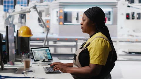 Technician monitors manufacturing data on pc in solar panel factory Stock Footage 309069101