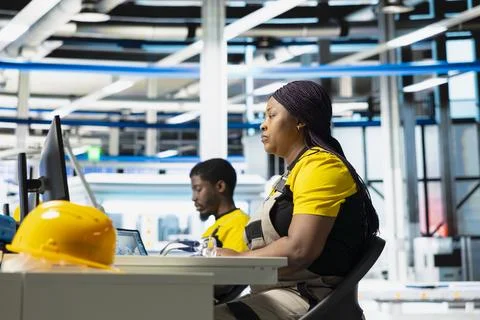 Technician monitors manufacturing data on pc in solar panel factory Stock Photos