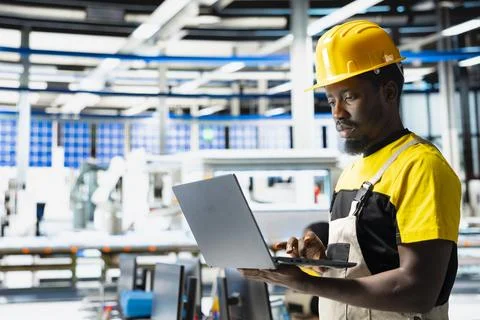 Technician monitors manufacturing data on pc in solar panel factory Stock Photos