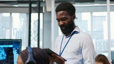 Technician next to office coworkers developing AI software applications Stock Photos