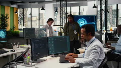 Technician in office solving tasks with artificial intelligence LLM chatbot Stock Footage 323144867