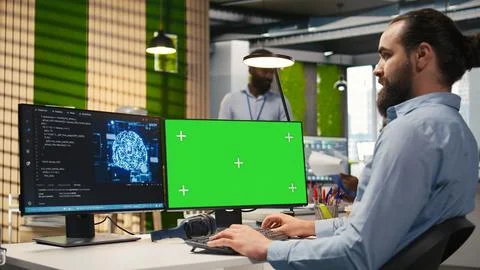 Technician in office using green screen PC, automating repetitive tasks with AI Foto stock