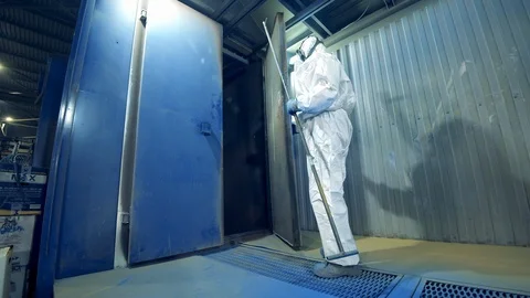 Technician opens a garage unit with metal framework. Industrial painting process Stock Footage 124259231