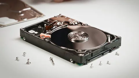 Technician opens hard drive casing, revealing magnetic platters, read write Stock Footage 315448169