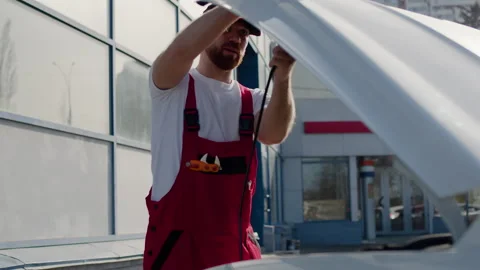 Technician opens hood start car repairs auto workshop meticulous work auto Stock Footage 274415470