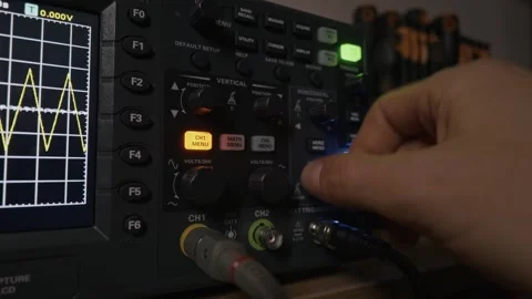 Technician Operating Digital Oscilloscope To Measure An Electronic Signal Stock Footage 327713415
