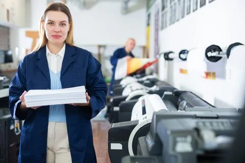 Technician operator changes paper on printer plotter machine Stock Photos