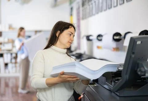 Technician operator changes paper on printer plotter machine Foto stock