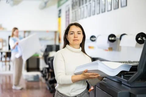 Technician operator changes paper on printer plotter machine Stock Photos