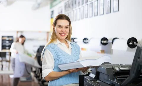 Technician operator changes paper on printer plotter machine Stock Photos