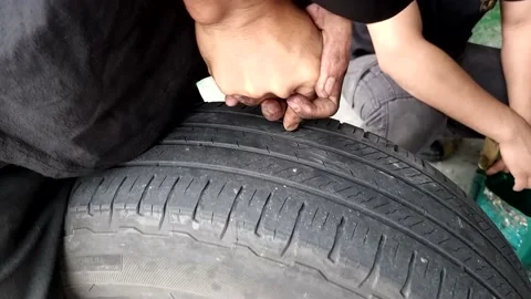 Technician patching punctured tire with rubber plug and verified no leakage with 스톡 동영상 239734778