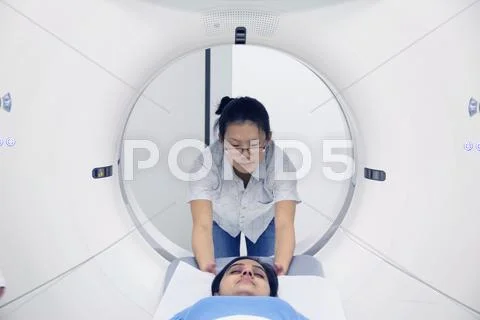 Technician With Patient In Ct Scanner