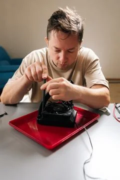 Technician performing computer hardware maintenance, installing cpu cooling Stock Photos