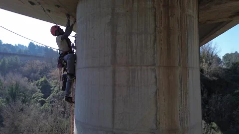 Technician performing inspection on bridge pylon Stock Footage 306919979